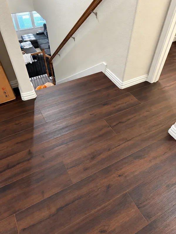 Installed brown wood-look plank flooring beside a staircase
