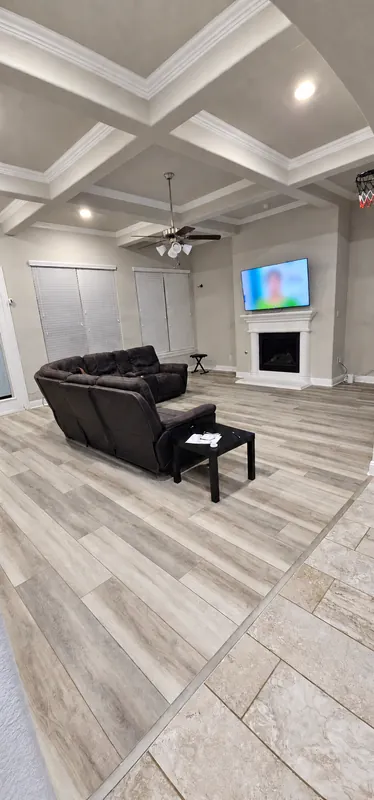 Installed grey wood-look floor in a living room with coffered ceiling