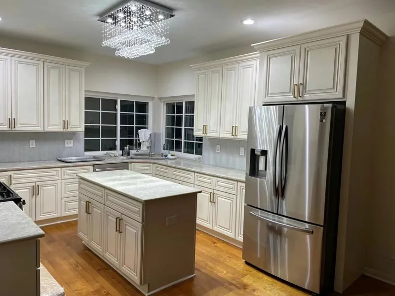 Kitchen with cream raised-panel cabinets, light quartz countertops and a center island, by Acue Marmonite