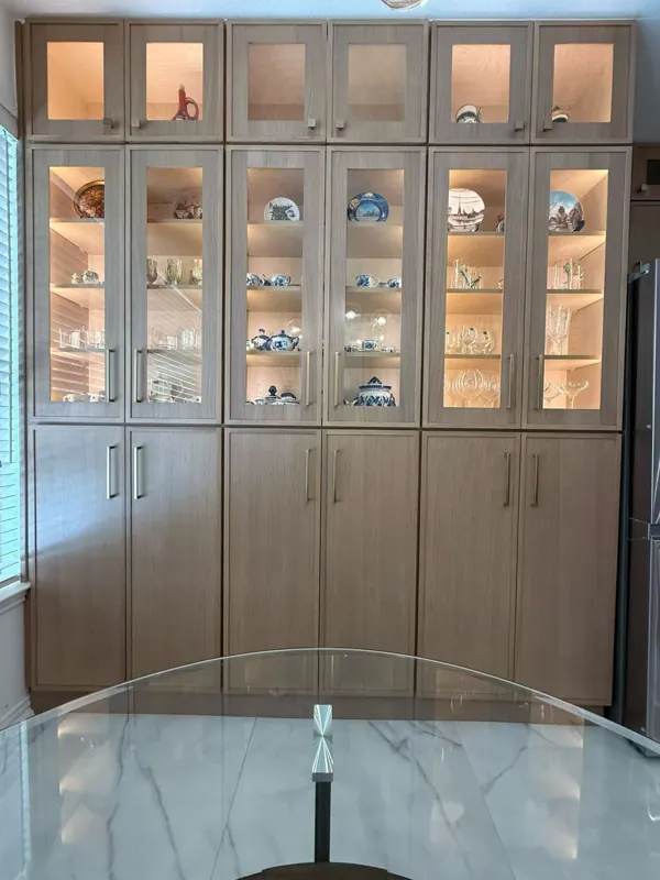 Floor-to-ceiling wood cabinets with lit glass display doors, by Acue Marmonite