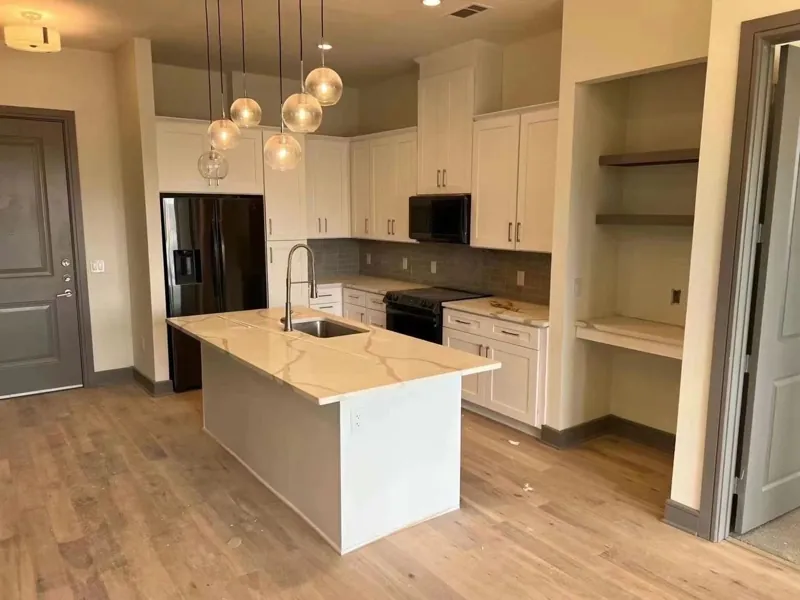 Kitchen with white cabinets, grey island and Calacatta-look quartz countertops, by Acue Marmonite