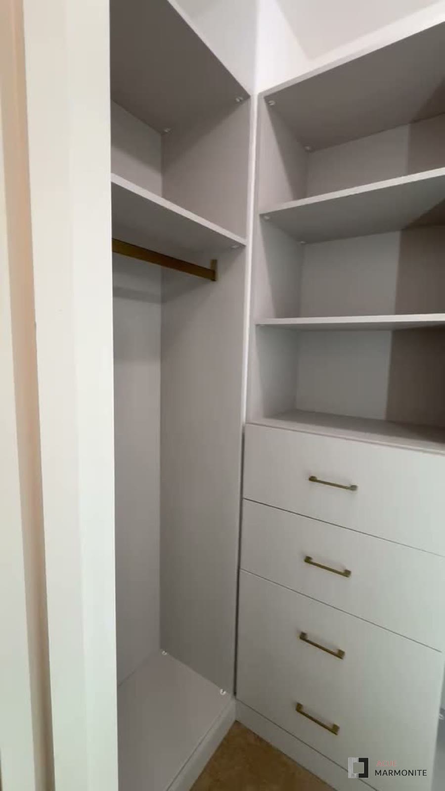 Reach-in corner closet with hanging rod and drawer stack, installed by Acue Marmonite