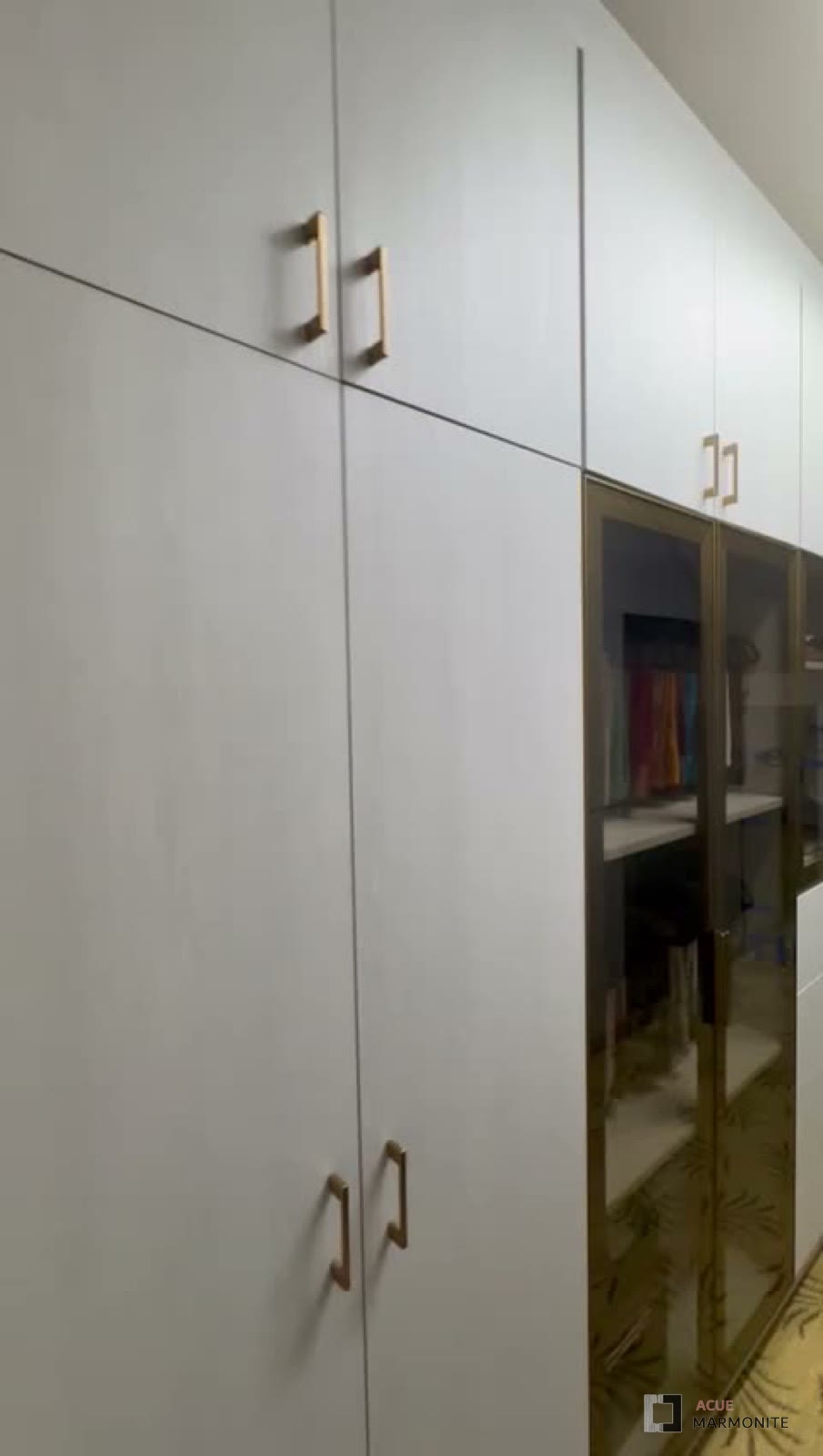 Reach-in wardrobe wall with glass-front cabinets, installed by Acue Marmonite