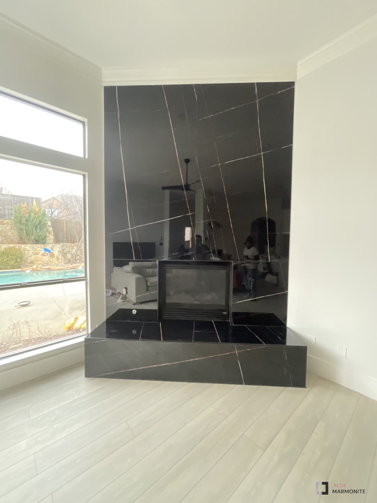 Saint Laurent book-matched fireplace wall with raised hearth, installed by Acue Marmonite