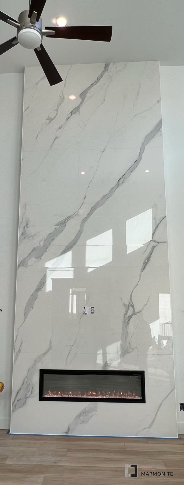 White book-matched porcelain fireplace wall, installed by Acue Marmonite