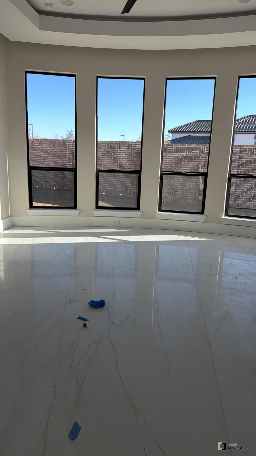 Polished tile flooring in a sunlit bay window room
