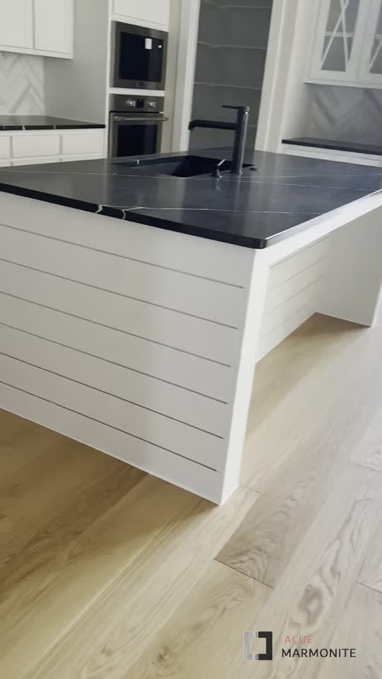 Kitchen remodel with black waterfall island and shiplap cabinetry, completed by Acue Marmonite