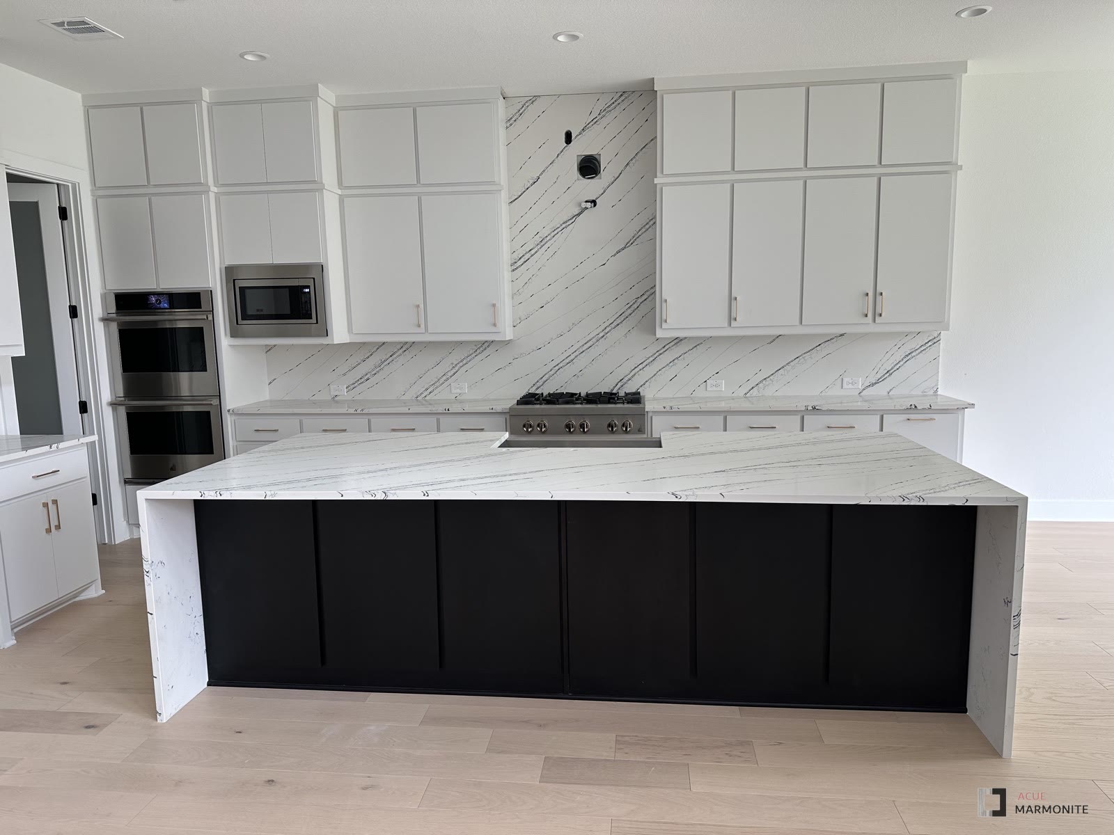 Quartz kitchen island with diagonal-veined backsplash, installed by Acue Marmonite