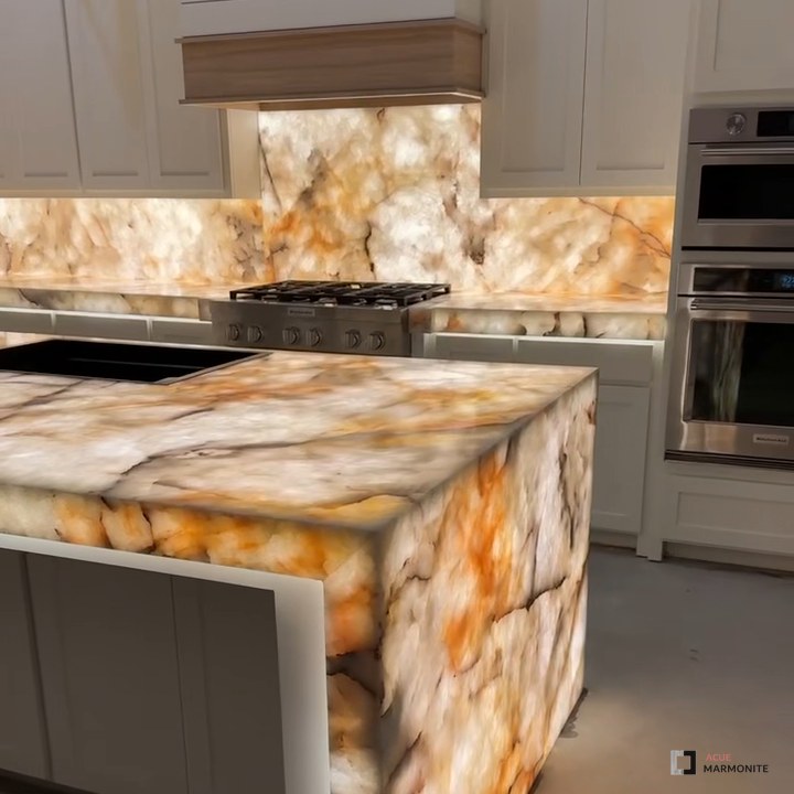Backlit Cristallo quartzite waterfall island and full-height backsplash glowing in a Frisco, TX kitchen, installed by Acue Marmonite