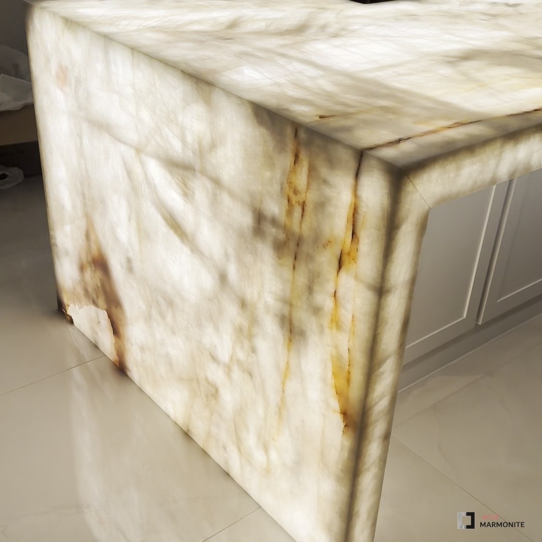 White Cristallo quartzite waterfall island glowing with LED backlighting, installed by Acue Marmonite